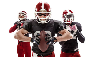 The three american football players posing with ball on white background