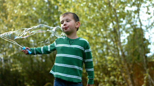 Young boy making bubbles, slow motion
