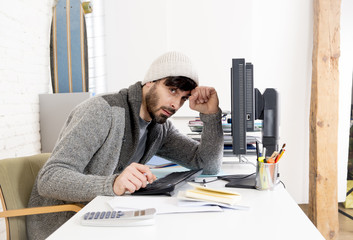 young worried businessman in cool hipster beanie look looking desperate having problem working in stress