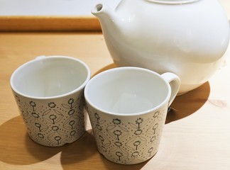 Two Empty Tea Cups with Tea Pot