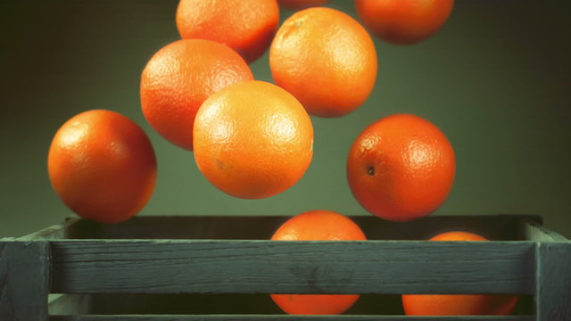 ripe orange falls in the box, slow motion