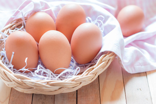 Eggs in a basket on wooden table.