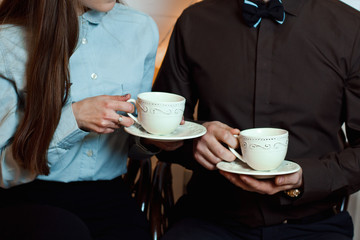 man and woman in business suits are drinking tea (coffee)