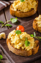 Scrambled eggs with herbs and garlic on toasted bread