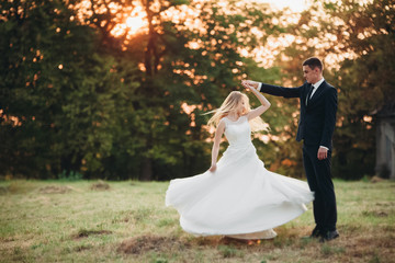 Beautiful romantic wedding couple, groom and bride hugging near old castle on sunset