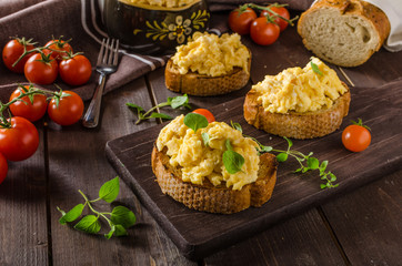 Scrambled eggs with herbs and garlic on toasted bread