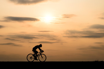 Fototapeta na wymiar Silhouette of cyclist motion on sunset background