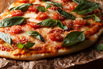 Homemade italian pizza with mozzarella, tomatoes and basil leave