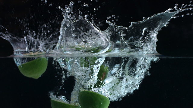 Limes splashing into water