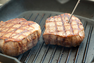 grilled beef steak with rosemary on frying pan
