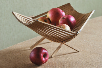 red apples in wood basket on green background