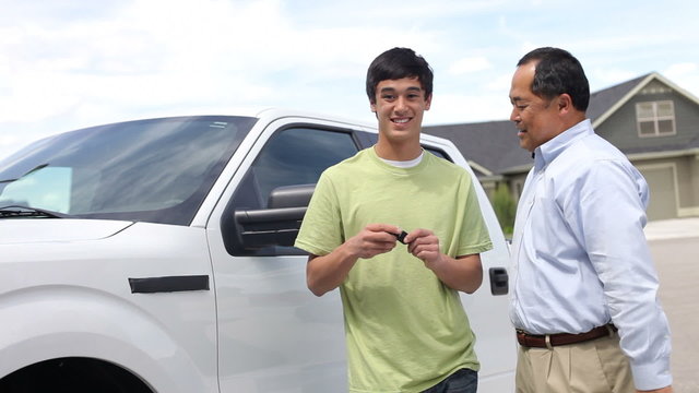 Father hands son keys to truck