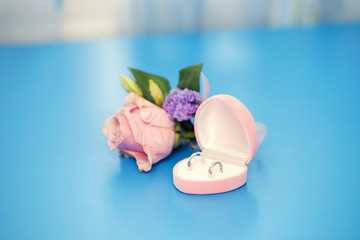 wedding rings in a pink box and groom's buttonhole