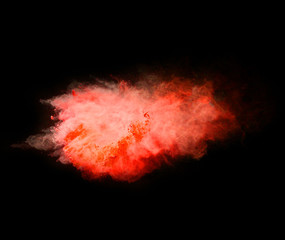 Explosion of red powder on black background