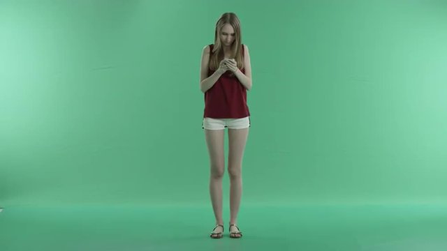 woman writes a message on the phone on a green screen