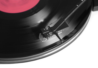 Rotation black vinyl record with red label on turntable player in silver case. Horizontal photo top...