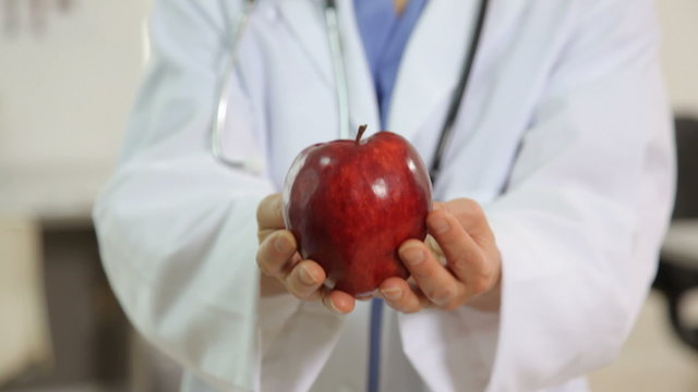 Doctor holding apple in hands