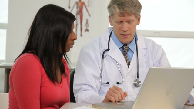 Doctor and patient look at laptop computer