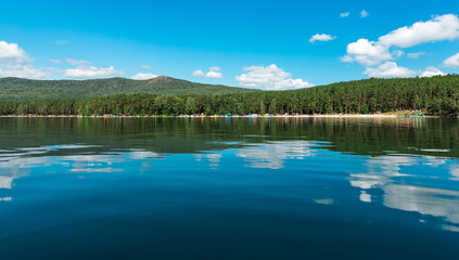 Obraz na płótnie Canvas Russia. The Southern Urals. Lake Turgoyak. Clouds reflected on the water surface of the lake in clear weather. 