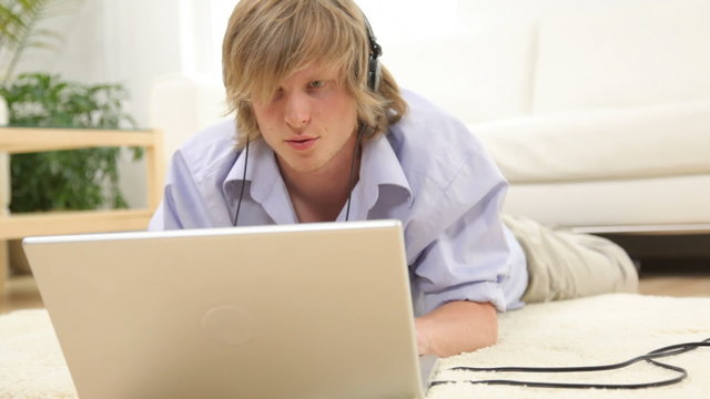 Young man listening to music on laptop computer