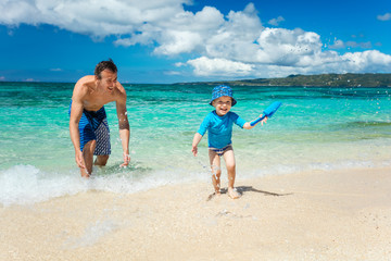 Father and son having fun on a tropical beach