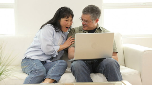 Mature Asian couple using laptop computer