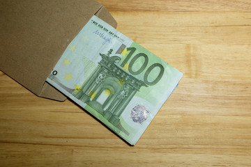 Euro banknotes in salary brown envelope.