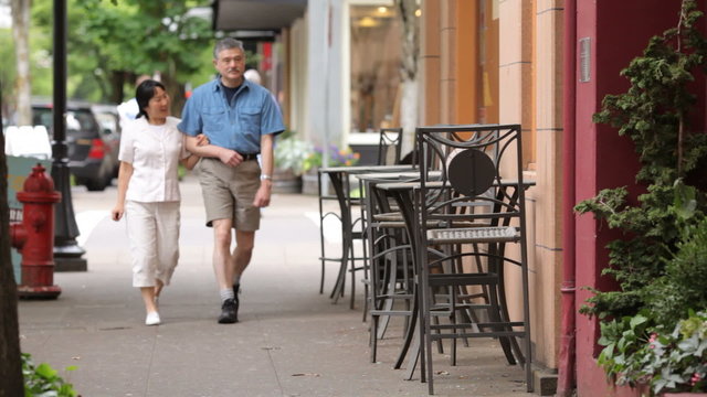 Mature couple walking down street together