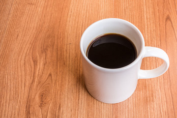 Cup of hot black coffee on wood table