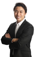 A young and professional businessman standing in front of a white background smiling looking at camera.