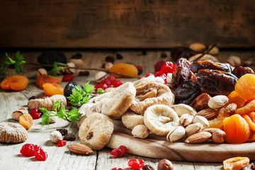 Delicious dried figs and dried fruit and nut mix on dark wooden