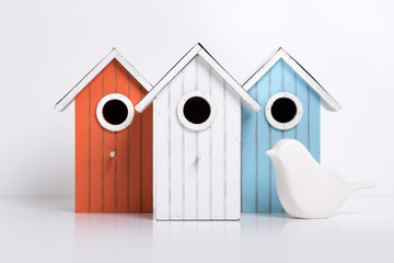 Vogelhäuser in verschiedenen Farben mit Vogel