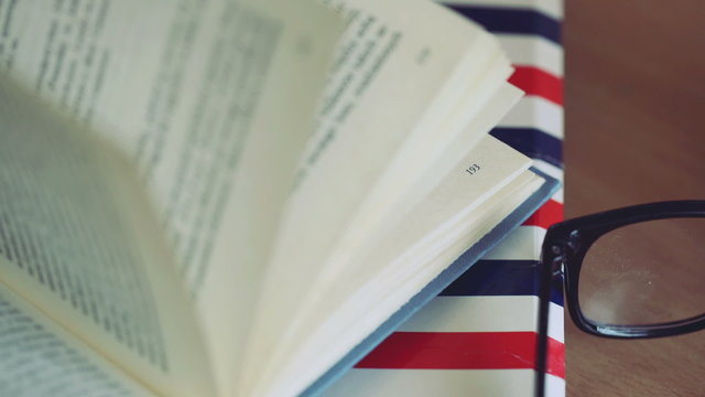 View of the open book lying on the folder next to the glasses
