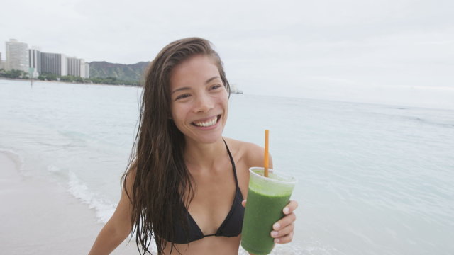 Green detox cleanse vegetable smoothie bikini woman. Healthy sport girl drinking fresh and happy after swim. Fitness and healthy lifestyle concept multicultural Asian Caucasian female model. 96 FPS.