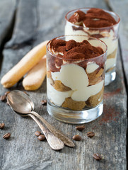 tiramisu in glass on wooden surface