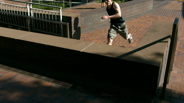 Free Runner vaults over brick divider, slow motion