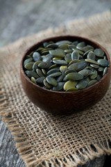 pumpkin seeds in a bowl over wooden surface