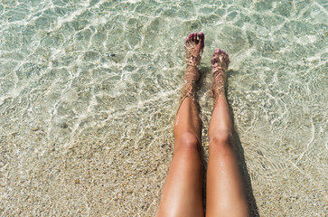 Closeup of womans feet in lagoon water. Over head view.