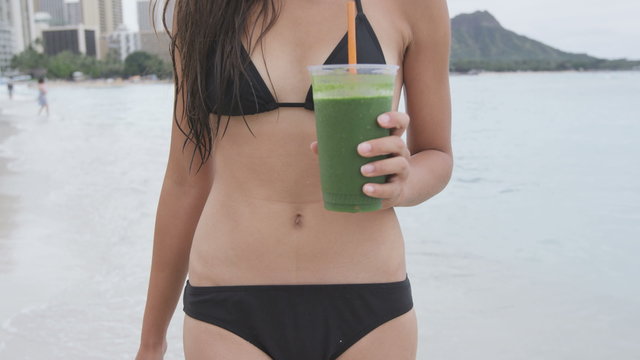 Green detox vegetable smoothie and woman stomach. Female drinking vegetable smoothie on beach on summer day. Fitness and healthy lifestyle concept, RED EPIC SLOW MOTION 96 FPS.