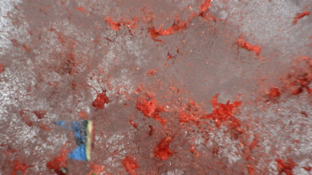 Watermelon painted like earth is shot with gun, slow motion