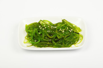 Seaweeds salad on small white dish plate