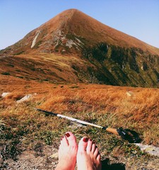 Woman resting under Hoverla mountain while trekking