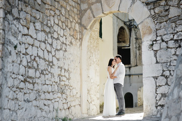 Fototapeta na wymiar happy couple bride and groom tenderly embraced in wedding day in Sperlonga, Italy
