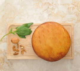 head of smoked Suluguni cheese on wooden Board with walnuts and