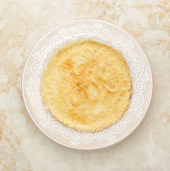 pancake on a plate on a marble background. top view