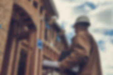 Blurred Construction Worker Inspecting Home Construction Site wi