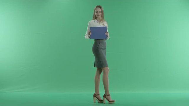 business woman holding a blue screen on a green background