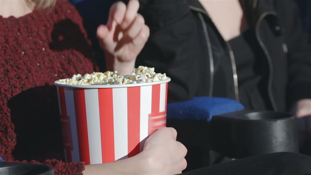 Close up hand holding a bucket of popcorn