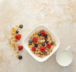 Muesli cereal with raspberries and blueberries. Mug of milk. Hea