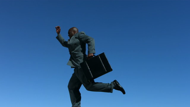 Businessman with briefcase leaps, slow motion